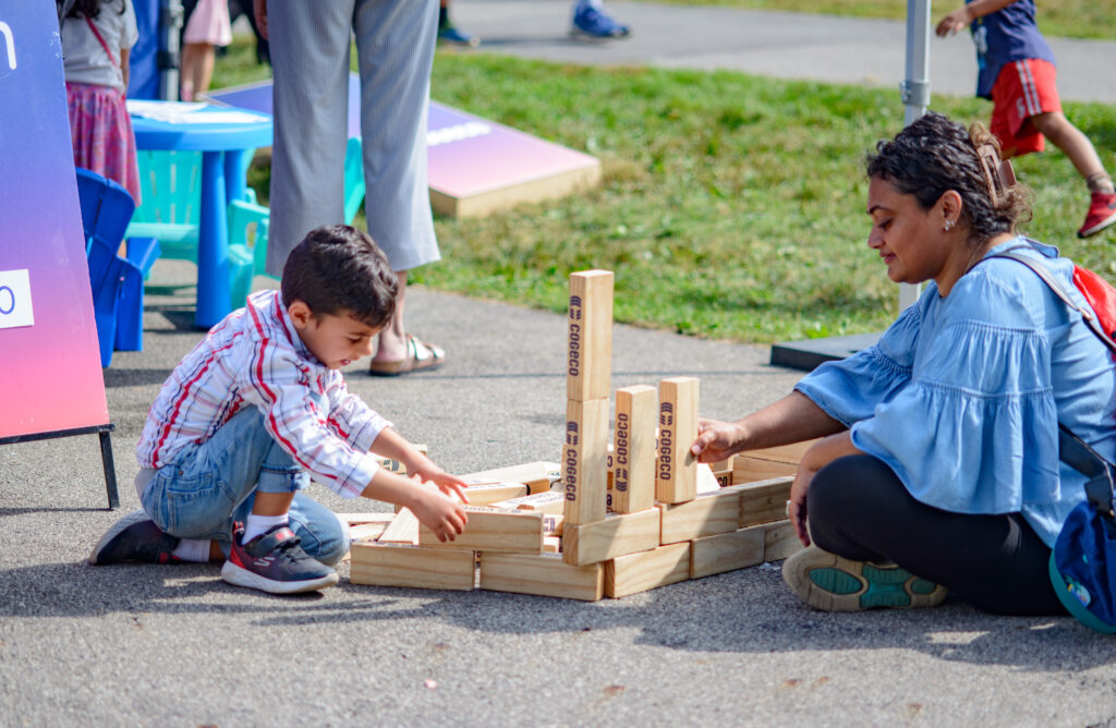 Children and parents at the Telling Tales Festival play with cogeco branded blocks at the Telling Tales Festival in 2024. a burlington event held at the royal botanical gardens.